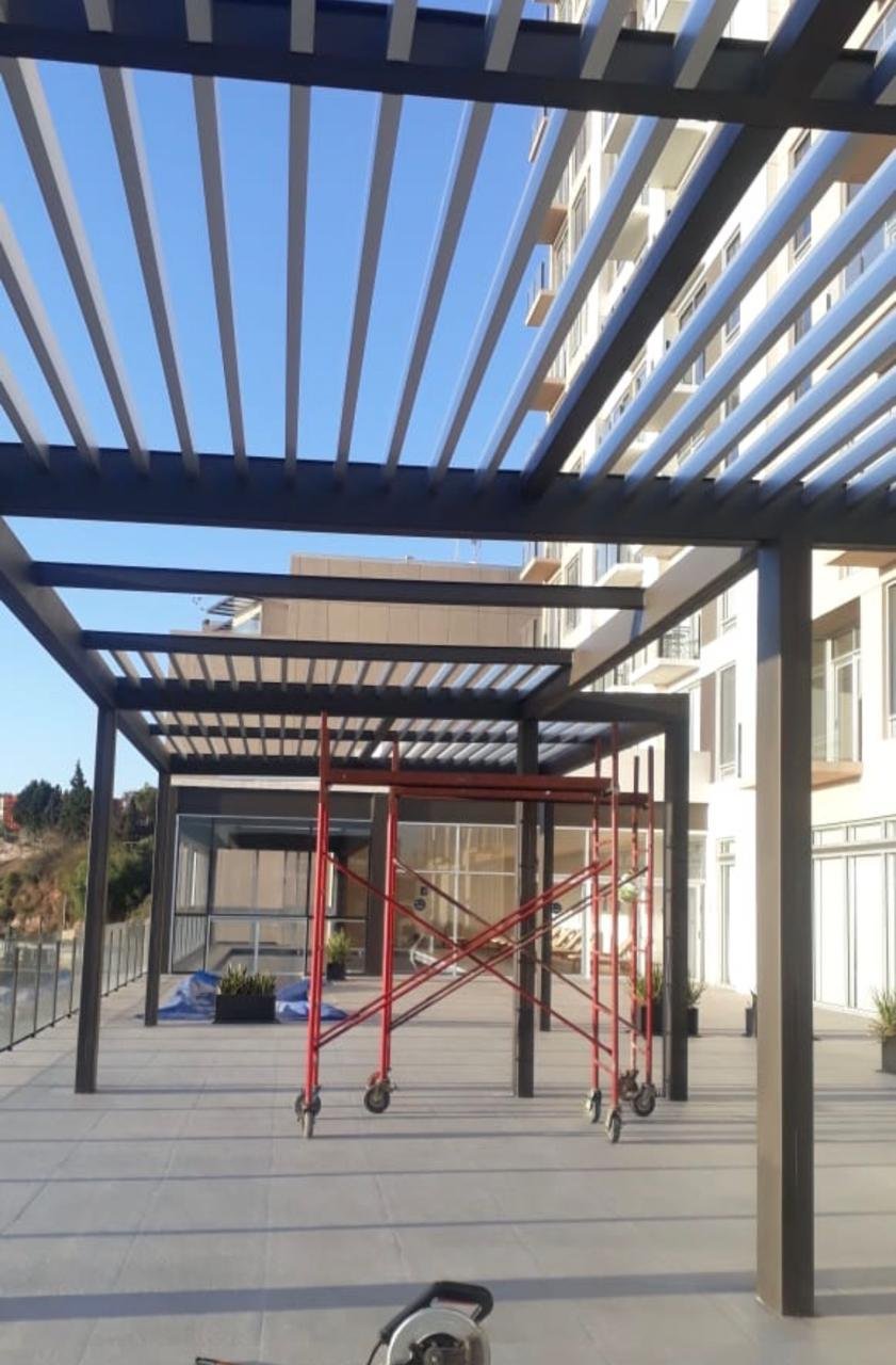 Pérgola de acero con listones en terraza de edificio